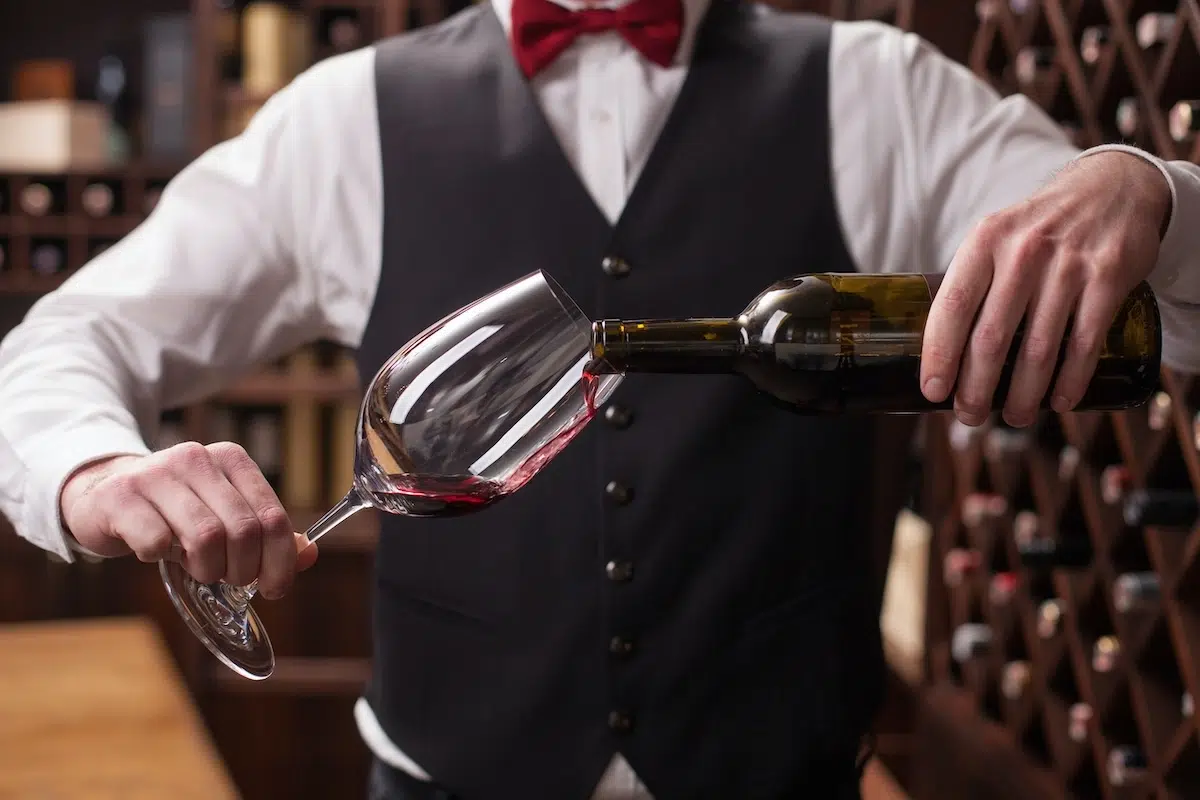 imagem mostra um sommlier com vinho